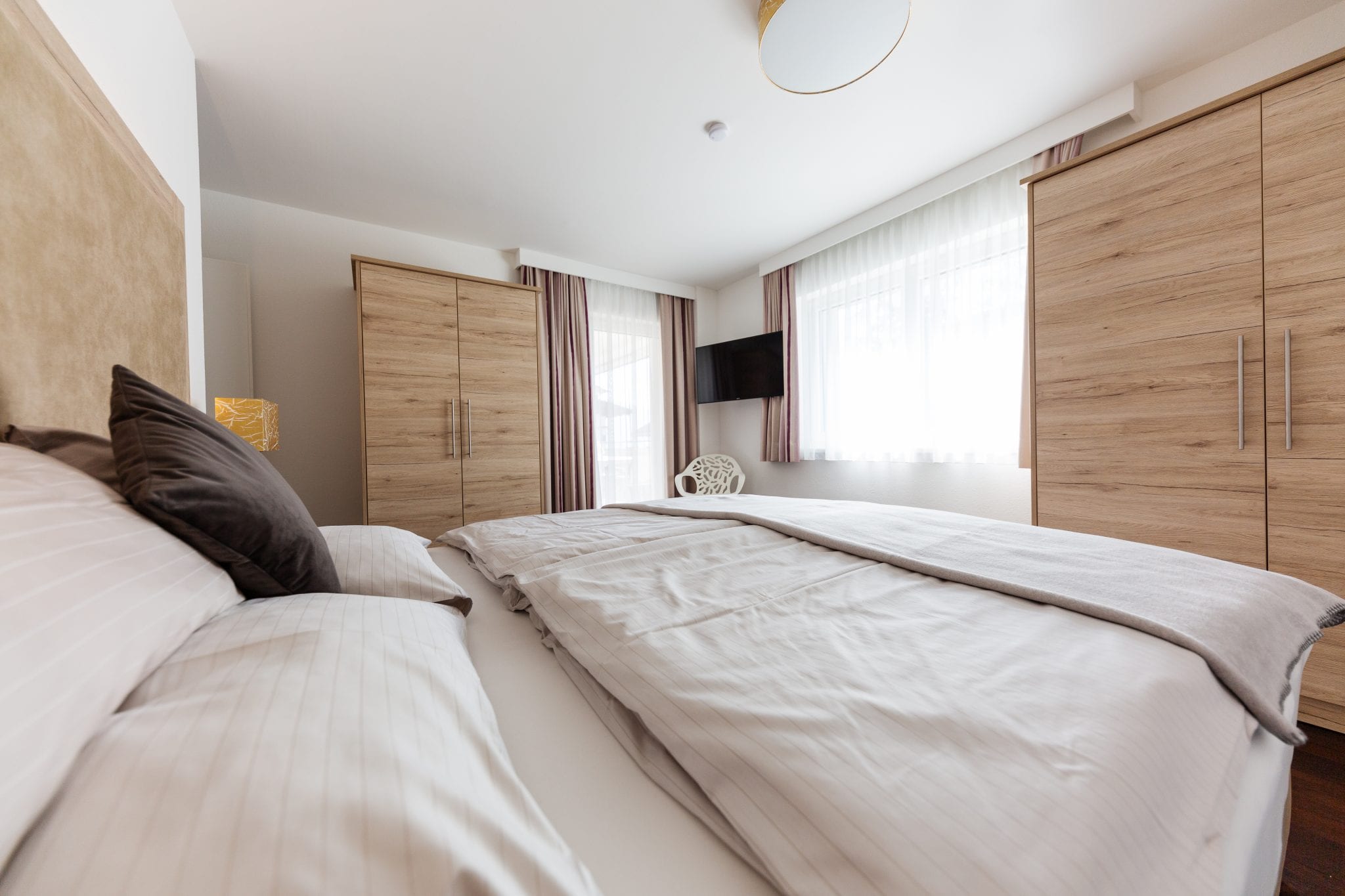 Schlafzimmer mit Doppelbett, Allergikerbettwäsche, Einbauschrank, TV und Leselampe – Family Apartment da Peatala Apartments Serfaus Sommer