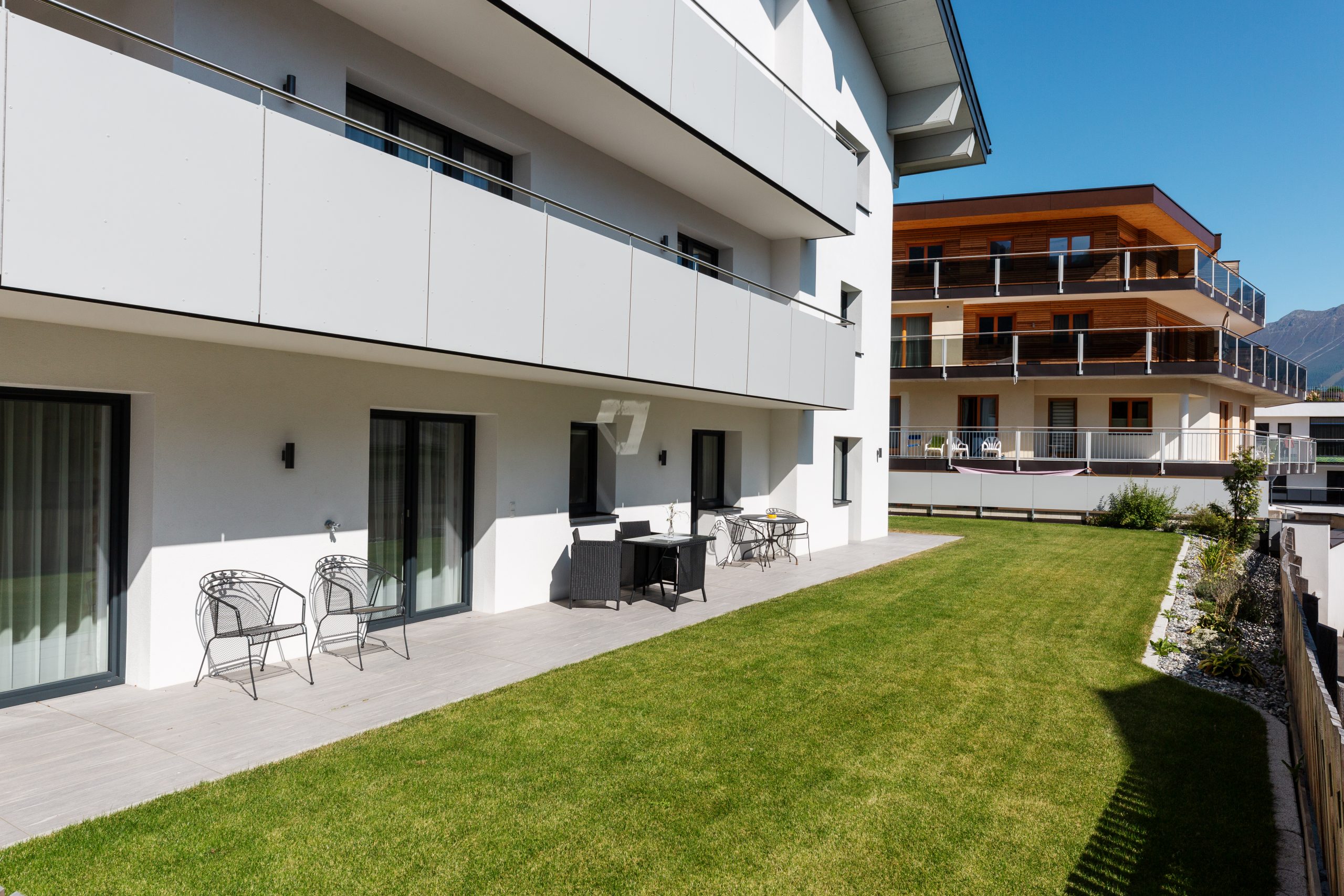 Terrasse mit Sitzgruppe und Tischen für 6 Personen, direkter Zugang zum Garten – Garden Apartment da Peatala Apartments Serfaus Sommer