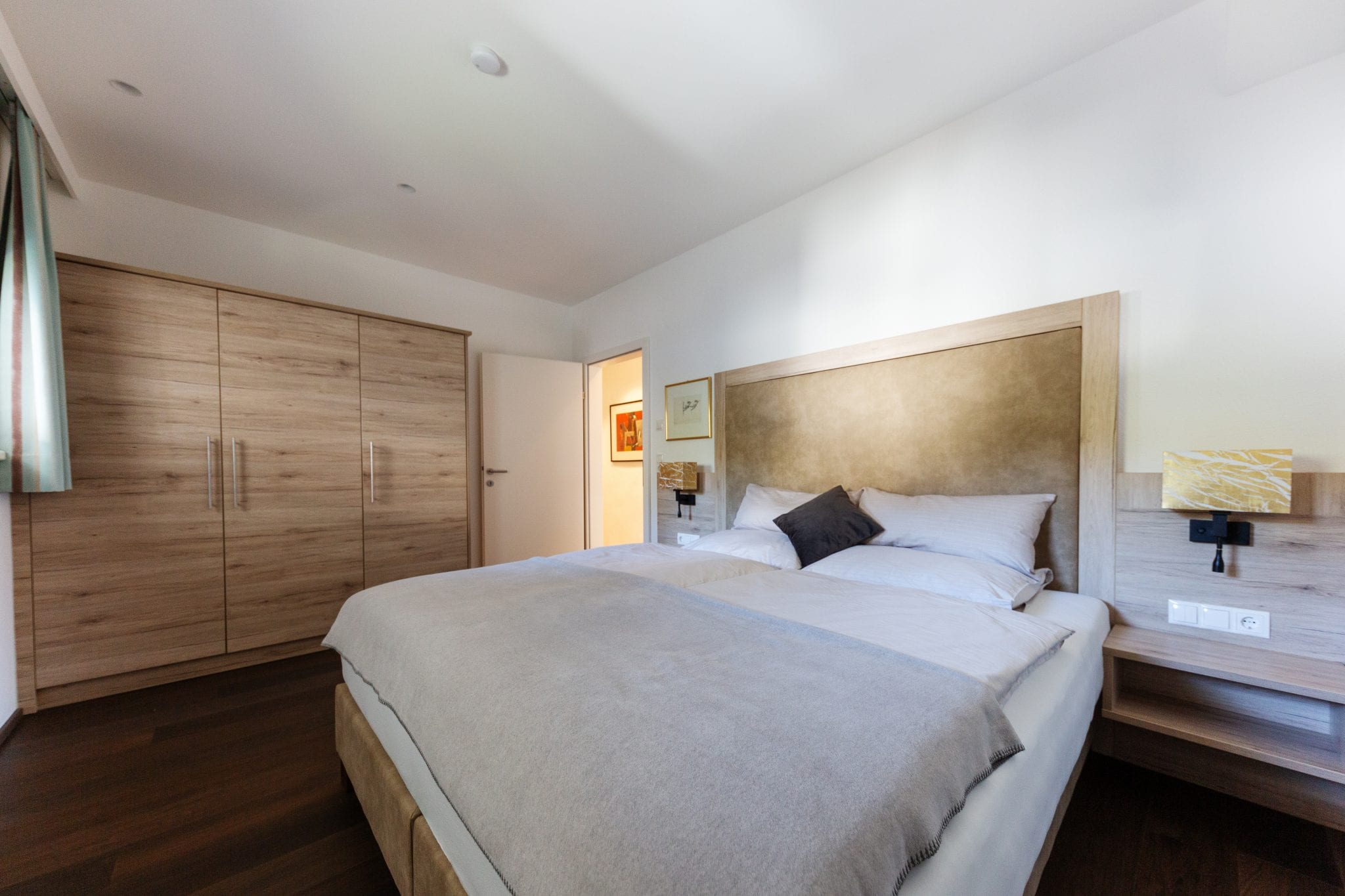 Schlafzimmer Nord mit Doppelbett, Allergikerbettwäsche, Einbauschrank, TV und Leselampe – Lifestyle Apartment da Peatala Apartments Serfaus Sommer