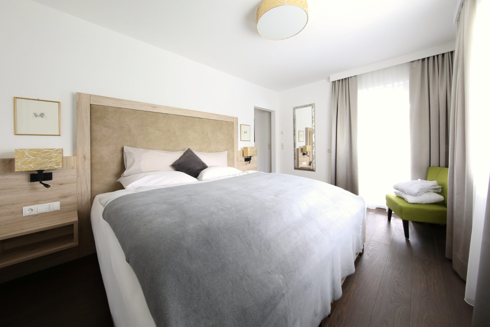 Upstairs bedroom with double bed, bedside tables, TV and balcony – Lifestyle Apartment da Peatala Apartments Serfaus summer