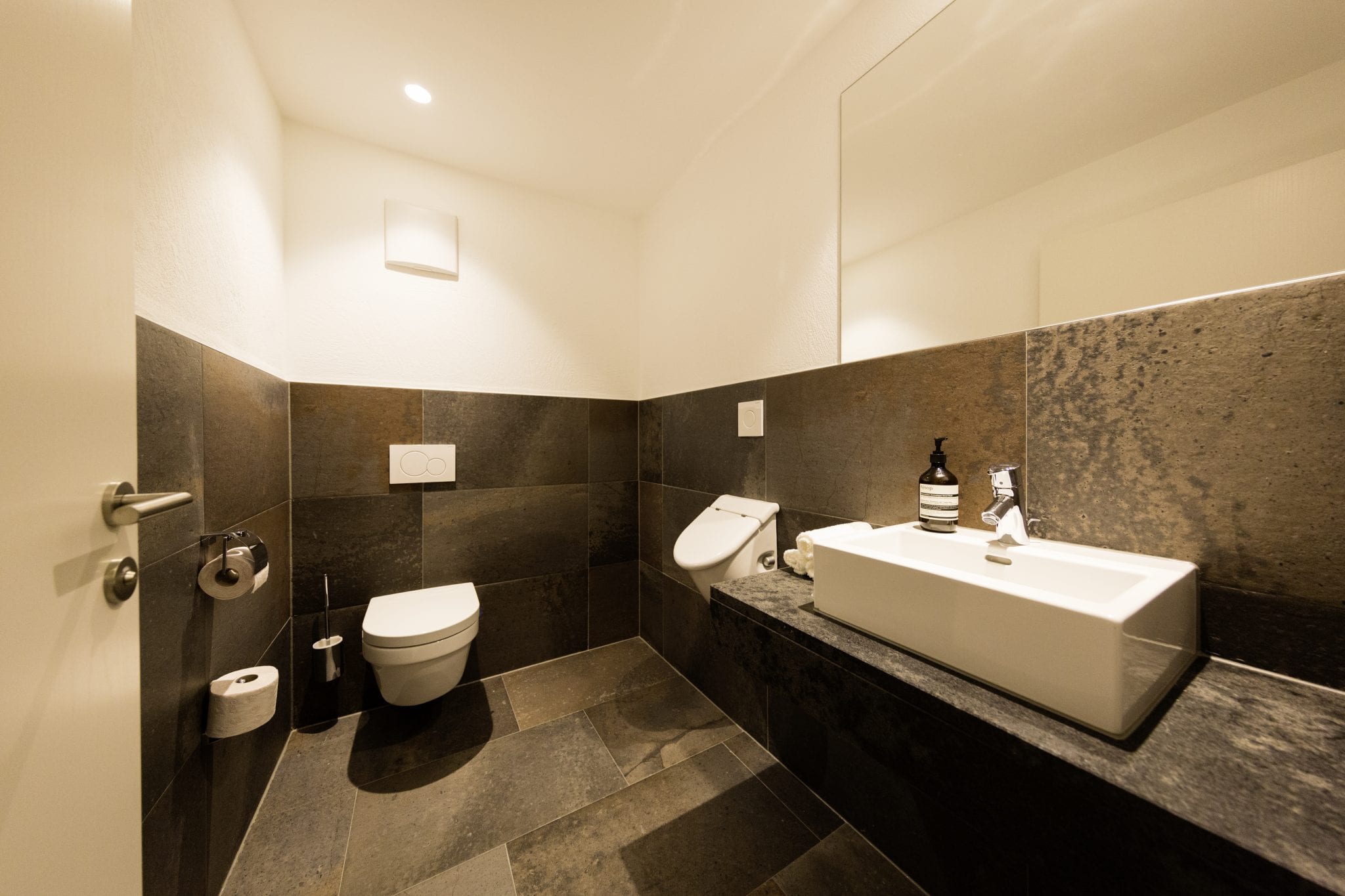 Separates WC mit Sitztoilette, Pissoir, Toilettenpapier, Handseife und Creme – Lifestyle Apartment da Peatala Apartments Serfaus Sommer
