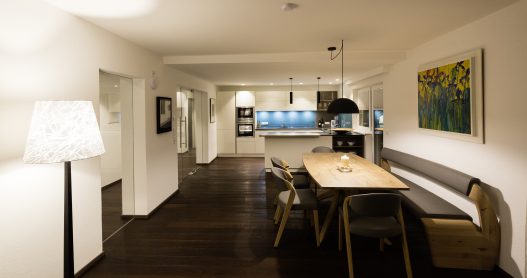 Wohnküche mit Esstisch für bis zu 6 Personen aus hellem, lokalem Holz im naturbezogenen Ambiente