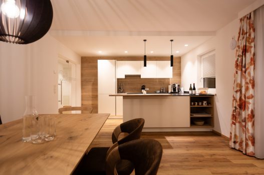 Voll ausgestattete Küche mit angrenzenden Esstisch aus hellem Holz für bis zu 6 Personen