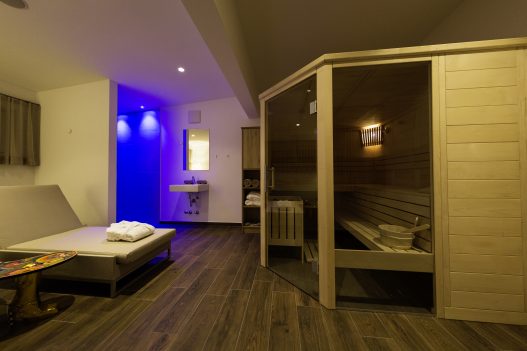 Wellness Ruheraum mit finnischer Sauna, Dusche und Aromadiffuser in entspannten blaulicht Ambiente