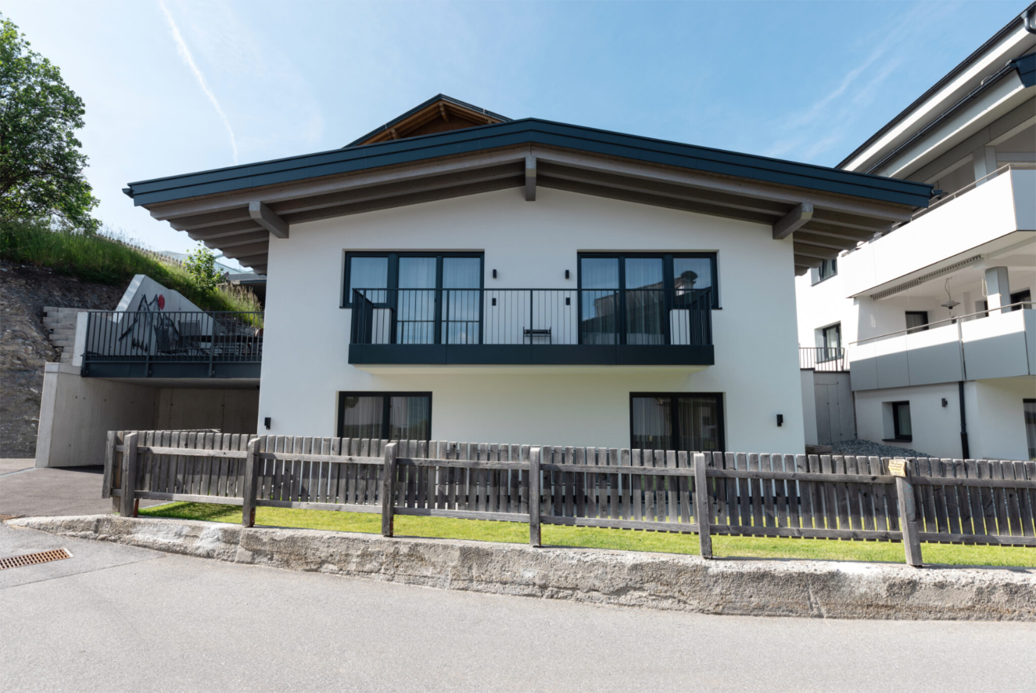 Rückseite des Mountain Chalets mit Terrasse und Balkonen – da Peatala Apartments Serfaus Sommer