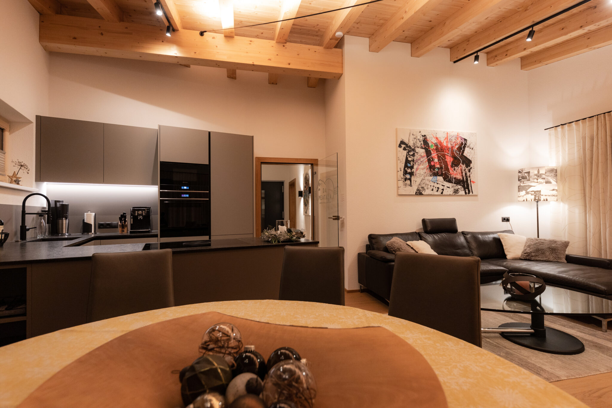 Wohnküche Rückansicht mit Esstisch, Stühlen und Küchenzeile – Mountain Chalet da Peatala Apartments Serfaus Winter